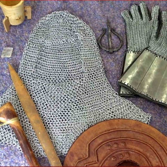 Various viking equipment laid out, including chainmail headgear and gloves