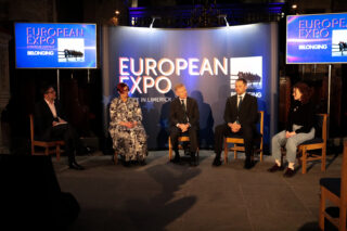 Five people seated on a panel at the European Expo in Limerick. They're in discussion with a backdrop that reads 