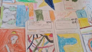 Colourful children's drawings and handwriting on a table, featuring abstract shapes, vibrant patterns, and a playful, creative atmosphere.