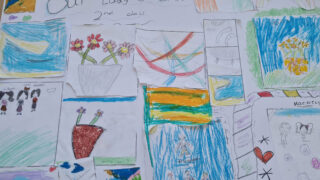 A collage of colourful children's drawings featuring flowers, a rainbow, boats, and abstract shapes. Bright hues convey a cheerful, playful mood.