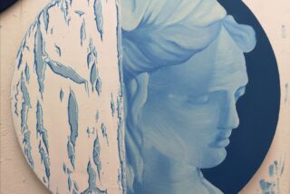 A round painting split in half; left side shows abstract blue and white cracked patterns, right side depicts a serene blue classical bust in profile.