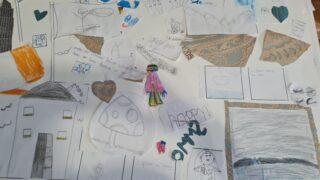 A colourful collage of children's drawings on white paper, featuring hearts, a child in pink, blue skies, and textured brown fragments. Creative, playful mood.