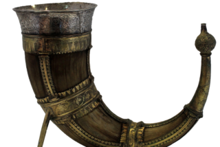 An ornate drinking horn with intricate metalwork and floral motifs. The polished surface and antique aesthetic evoke a sense of historical elegance.