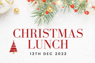 Festive Christmas lunch invitation with green pine branches, red berries, ornaments, and gold accents. Bold red text reads 