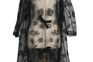 Vintage black lace coat with floral embroidery, sheer overlay, and three large bows on front. Chic and elegant design evokes a classic, timeless style.