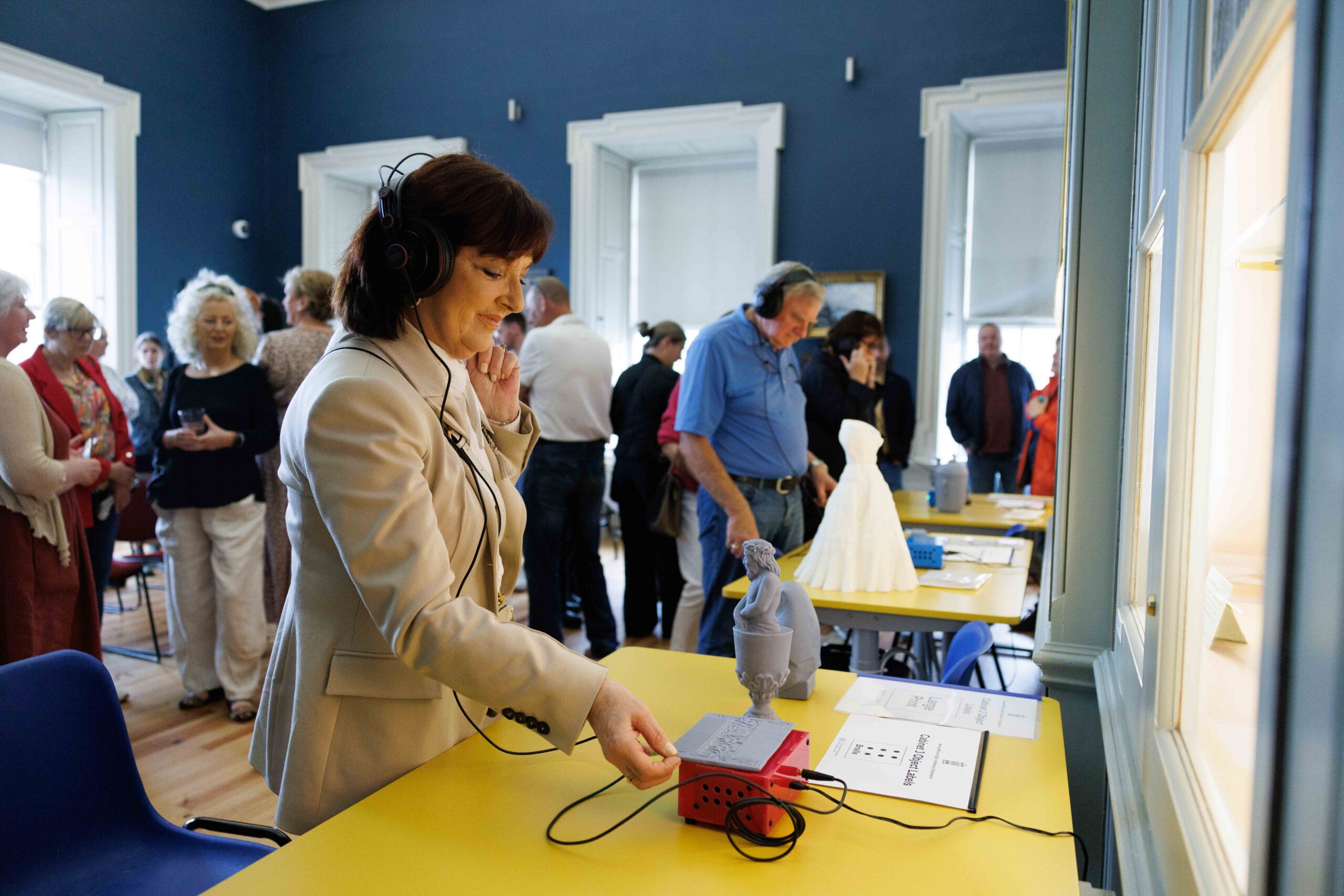 Woman wearing headphones at the Seeing without Sight exhibition at The Hunt Museum.