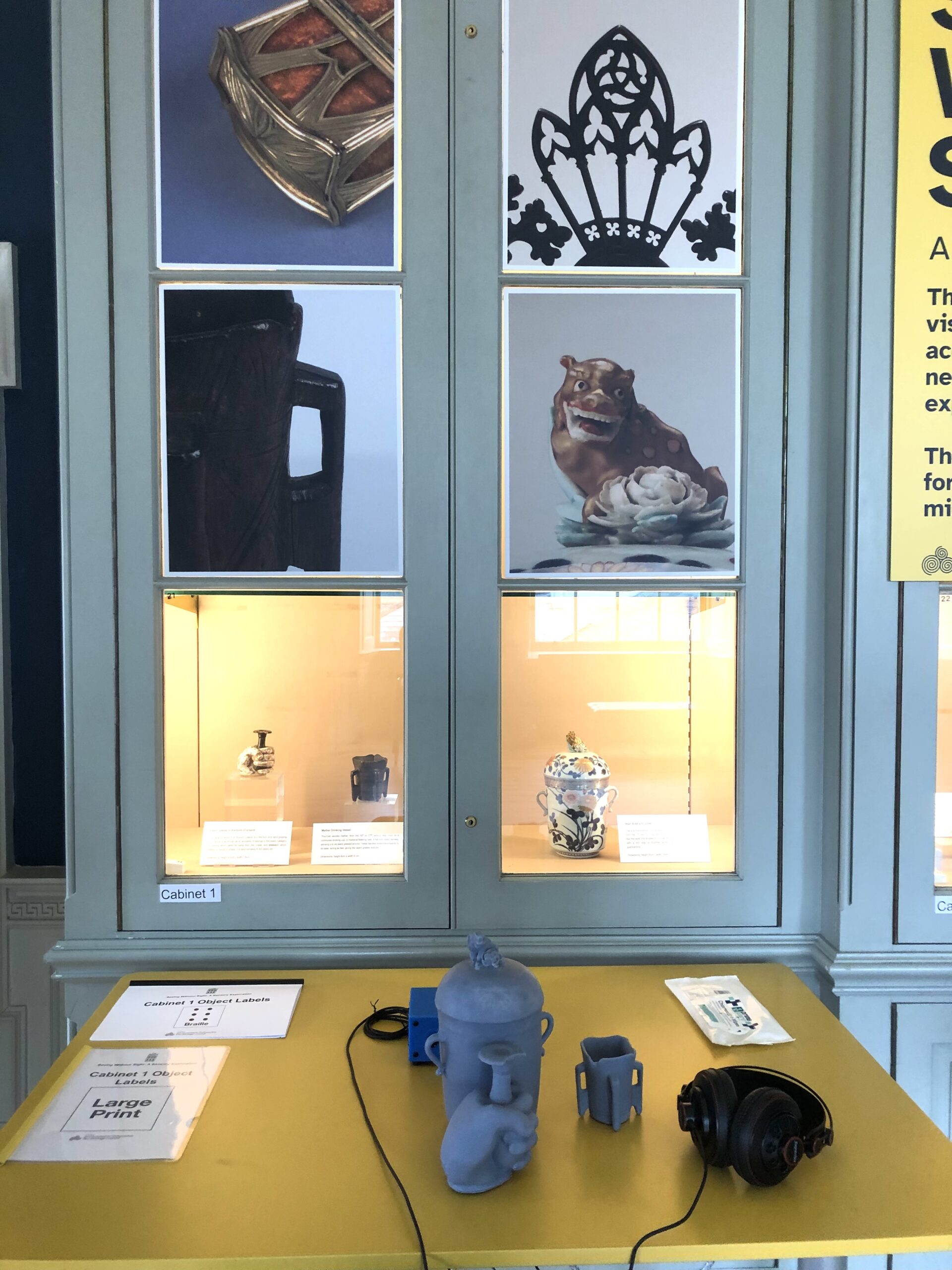 Display case with ceramic artifacts, tactile models, and headphones. The serene setting invites exploration of historic art pieces.