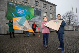 2 children hold a kite in front of the Hunt Museum