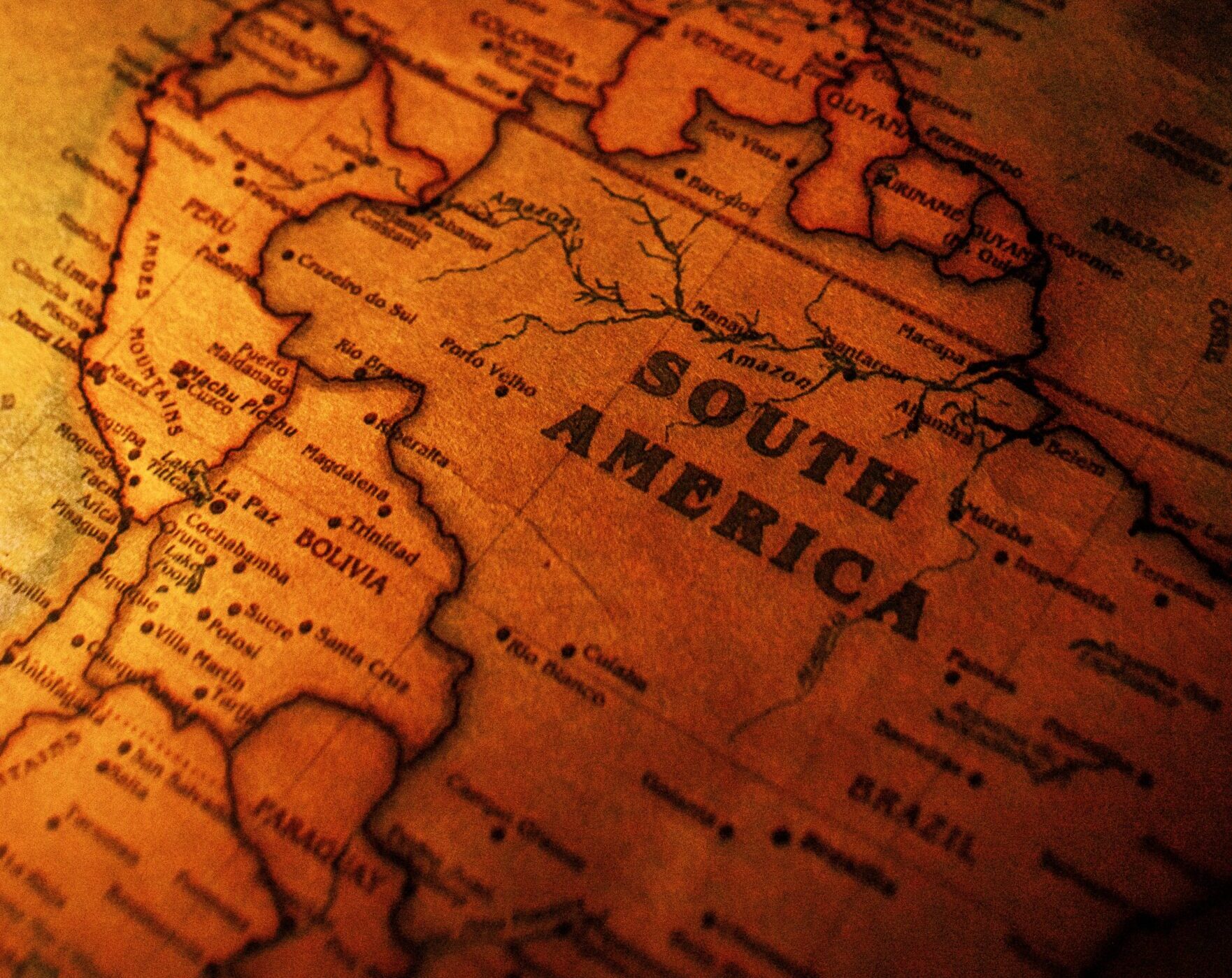 Vintage map of South America with an aged, sepia tone, showing country borders and names. The nostalgic style evokes a sense of exploration.
