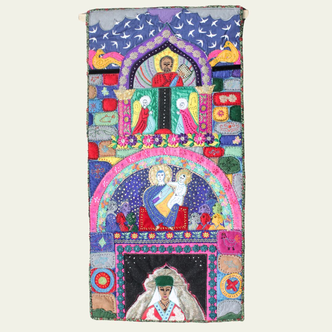 A colourful textile mural featuring intricate embroidery of religious figures and motifs, showcasing vibrant designs and patterns.
