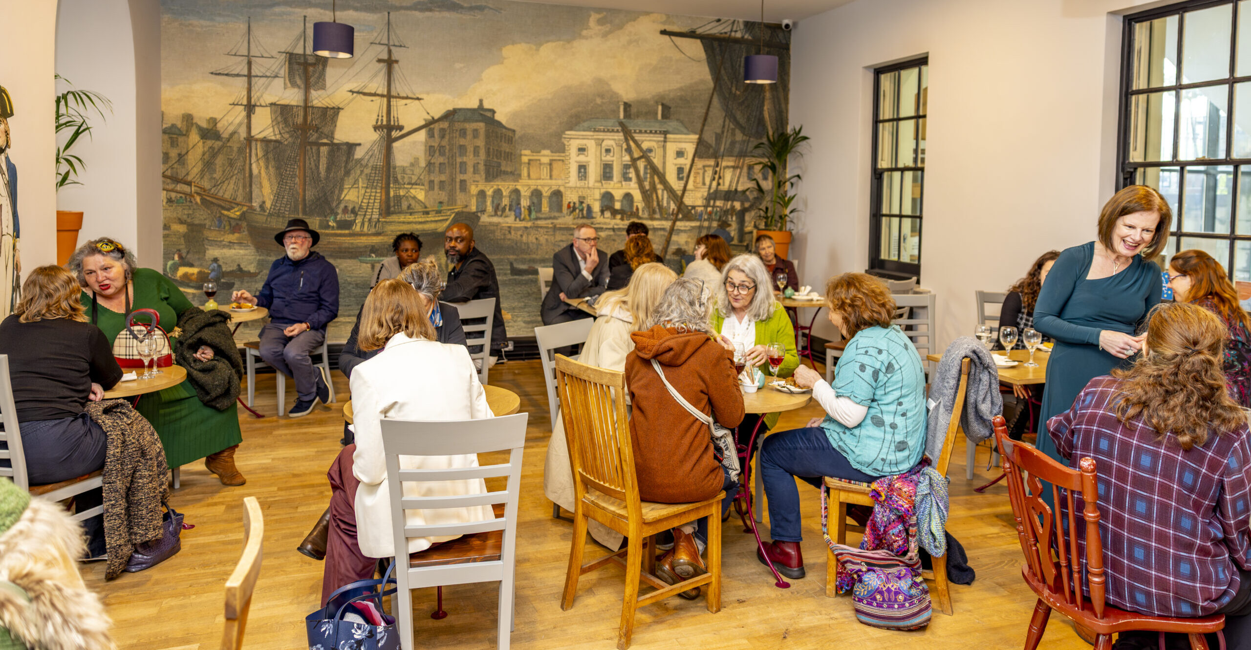 A café sitting area full of attendees of the launch of an exhibition.